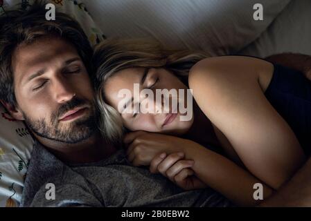 Couple sleeping on bed Stock Photo