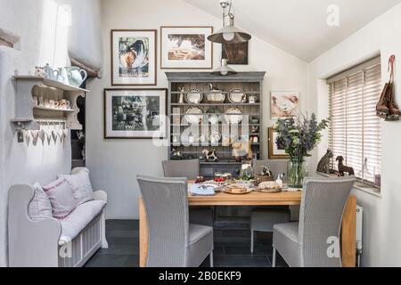 Pendant lights and closed Venetian blinds with wooden table and kitchen dresser Stock Photo