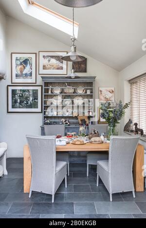 Pendant lights and closed Venetian blinds with wooden table and kitchen dresser Stock Photo