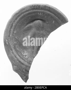 Fragment of a red-varnished oil lamp. The mirror was surrounded by concentric circles and is decorated with a relief image of an unclear figure. The spout was decorated with volutes., Oil lamp, earthenware, terracotta, 1.4 x 8 x 5.4 cm, 1st and 2nd century AD. 1-200, unknown Stock Photo