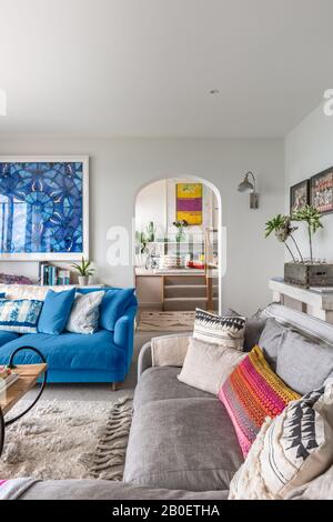 Damien Hirst artwork in living room with arch leading to open-plan kitchen-diner Stock Photo