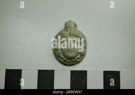 pendant, mask, Medusa, Pendant of light blue (iridescent) faience, in the form of a Medusa mask. Round pendant with a high-relief fold surrounded by wavy hair Stock Photo