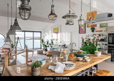 Reclaimed lights in open plan kitchen renovation with view to Fistral Beach Stock Photo
