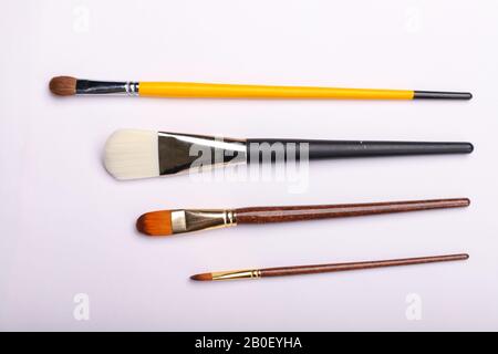 Art brushes of different sizes on a white background. Four brushes for painting, horisontal shot