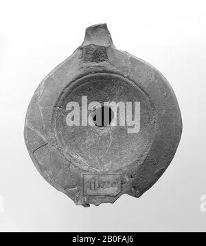 A brown-tinted light with a round body. The mirror is surrounded by concentric circles and undecorated with the small filling hole above the middle. Brand: CIVNDRAC, oil lamp, earthenware, terracotta, 3.1 x 8.8 x 7.7 cm, 2nd half 1st century to 1st half 3rd century AD. 50-250 AD, Tunisia Stock Photo