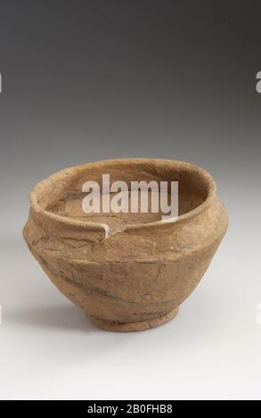 Frankish urn of red earthenware with flat bottom and stand ring. The shoulder is pointed and is located just under the upright narrow edge. Chips from the edge and loose shard, old bonding and an addition. Contains cremated residues., Bowl, urn, earthenware, h: 9.5 cm, diam: 14 cm, vmeb 525-725 AD, The Netherlands, Gelderland, unknown, unknown Stock Photo
