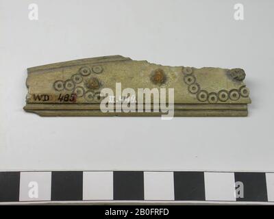 Fragment of a one-sided three-layer comb: part of a handle blade. Type: long comb. Decoration: handle leaf: dot circles forming a lying S and a lying V-shaped pattern. Lines that run parallel to the edges. Shape: straight base, slightly curved top. Tooth plates: 0. End plates: 0. Teeth: 0. Rivets: 3. Thin handle blade. Saw marks: So first the teeth plates and the handle blades have been attached to each other and then the teeth sawn in., Comb fragment, organic, antlers, l = 7,5 cm and b = 2,2 cm., Vmec 800-900 Stock Photo