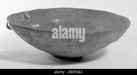 Smooth earthenware dish with an omphalos bottom and small foot on the edge. Old bonding and additions, the edge is damaged. Contains cremated residues., Bowl, earthenware, h: 9.5 cm, diam: 29.5 cm, prehistory -1200 Stock Photo