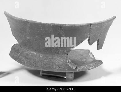 Large fragment of sharp profiled wide pot of earthenware. Very low belly, short shoulder and high, slightly curved edge. Very small foot. Dark gray polished, undecorated. Glueing and additions., Urn, fragment, earthenware, 16 x 16,5 x 9,7 cm, prehistory -600 Stock Photo