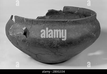 Gallo-Germanic bowl-shaped urn of earthenware with raised edge and 1 ear projection. Very unstable and loose bonding and additions, 8 separate fragments, some of which with glueing and additions. Contains cremated residues., Urn, earthenware, h: 15.5 cm, diam: 30 cm, prehistory -800 Stock Photo