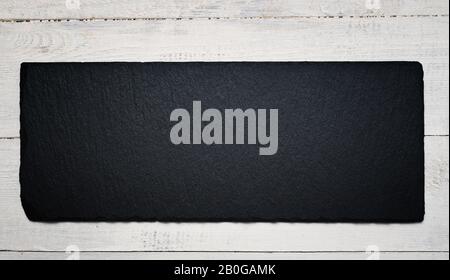 Slate black plate on wooden background Stock Photo
