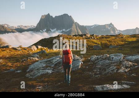 Woman traveler hiking in mountains with backpack adventure travel healthy lifestyle active summer vacations explore Norway Stock Photo