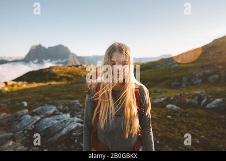 Woman hiking in mountains travel adventure healthy lifestyle blonde hair girl active summer vacations backpacking in Norway Stock Photo