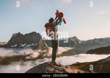 Father holding up baby child family travel vacations hiking in mountains with kid active healthy lifestyle outdoor in Norway happiness emotions Stock Photo