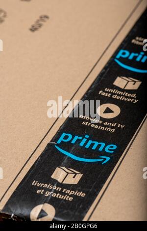 Paris, France - February, 20, 2020  : Amazon Prime logotype printed on cardboard box security scotch tape. Amazon Prime is a service from Amazon which Stock Photo