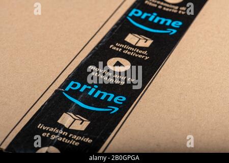 Paris, France - February, 20, 2020  : Amazon Prime logotype printed on cardboard box security scotch tape. Amazon Prime is a service from Amazon which Stock Photo