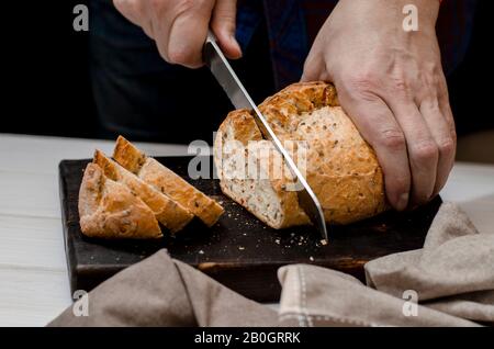 Homemade pastries. Men's hands cut homemade blush bread Stock Photo