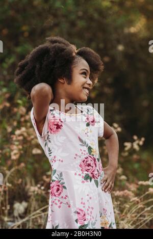 Portrait of young school-aged confident girl posing in field Stock Photo