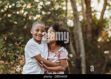 Close up portrait of brother and sister laughing at each other Stock Photo