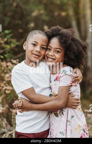 Brother and sister looking at the camera smiling Stock Photo - Alamy