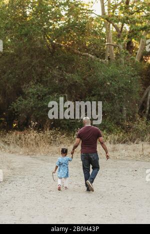 Father holding his daughter's hand Stock Photo - Alamy