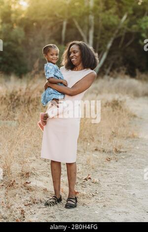 Portrait of happy grandmother holding young granddaughter on-loc Stock Photo