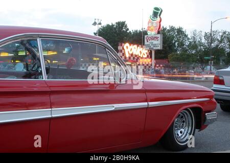 Ca: 1962 Chevy Impala and the sign for Porky's drive-in restaurant on University Avenue in St. Paul, Minnesota Stock Photo