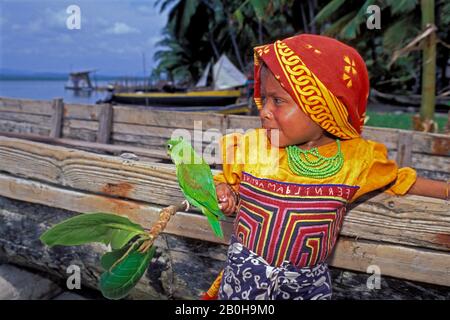 PANAMA, SAN BLAS ISLANDS, ACUATUPU ISLAND, KUNA INDIAN GIRL WITH PET PARROT Stock Photo