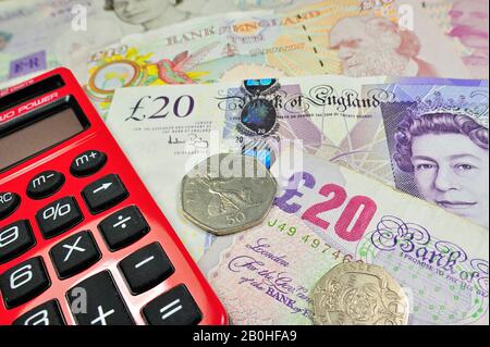 English banknotes in pound sterling and red pocket calculator Stock Photo