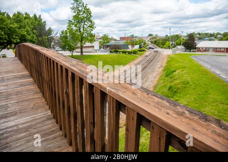 Footbridge crossing over railway, wooden pedestrian bridge closeup view, blur railroad and landscape, Oklahoma, US Stock Photo