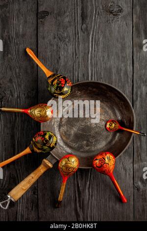 https://l450v.alamy.com/450v/2b0hk8t/vintage-cast-iron-skillet-and-wooden-old-painted-spoons-on-black-rustic-wood-background-tableware-with-copy-space-flat-lay-top-view-2b0hk8t.jpg