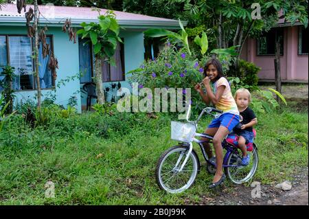 COSTA RICA, NEAR FORTUNA, MALEKU TRIBE, INDIAN VILLAGE, STREET SCENE WITH CHILDREN ON BICYCLE Stock Photo