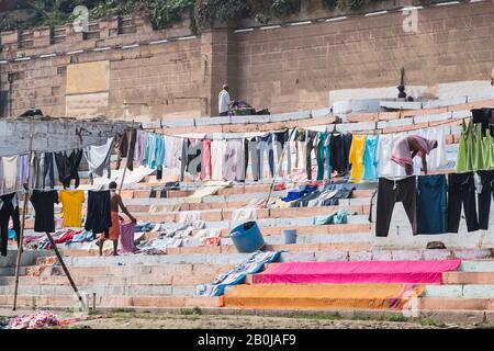 Colorful sheets and blankets near a ghat, waiting to get dried in the sunlight near the Ganges river. Indian lifestyle. Varanasi, India. Stock Photo