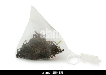 Close-up pyramid tea bag with black earl gray tea isolated on white background. Stock Photo