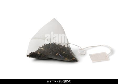 Close-up pyramid tea bag with black earl gray tea isolated on white background. Stock Photo