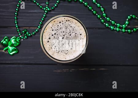 Glass of dark stout beer and traditional clover shaped decor Stock Photo
