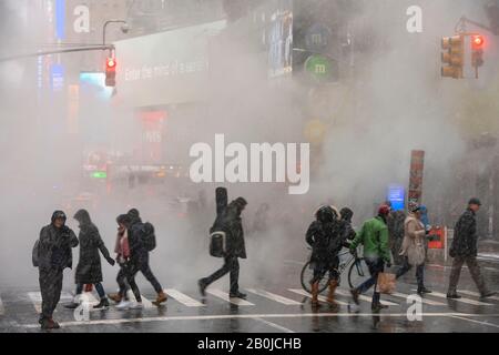 Steam rises and drifts over the Avenue among Midtown Manhattan buildings in the snow day around the Times Square in New York City NY USA on Jan. 2020. Stock Photo