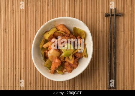 bowl of sweet and sour chicken on a table Stock Photo