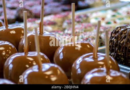 Caramel apples and trays of sweet treats are on display at a candy shop Stock Photo