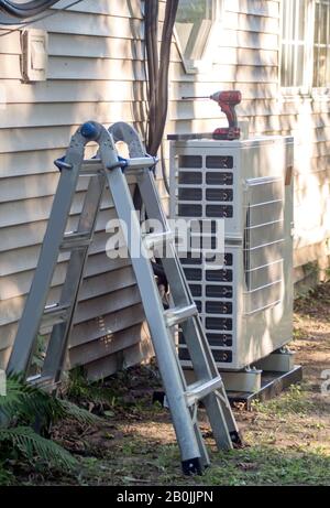 A mini split HVAC system is being installed in a home, for energy efficient heating and air conditioning Stock Photo