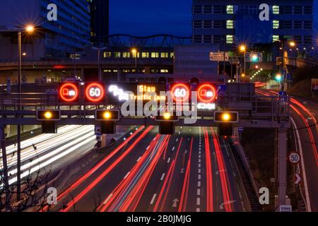 Wien, Vienna: freeway A22 Donauuferautobahn, car light trails, sign traffic jam, sign speed limit in 22. Donaustadt, Wien, Austria Stock Photo