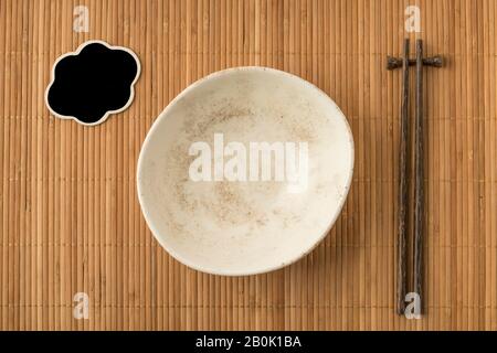 an empty bowl, blank chalkboard and chopsticks on a table Stock Photo