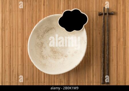 an empty bowl, blank chalkboard and chopsticks on a table Stock Photo