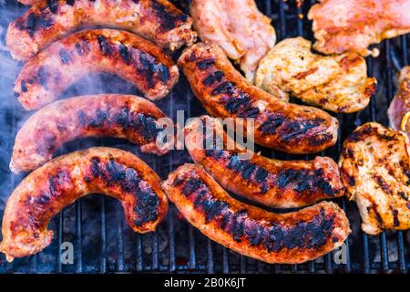 Pork meat and sausages grilled on a charcoal barbeque. Top view of tasty barbecue, food concept, food on grill and detail of food on the grill Stock Photo