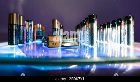 Rows of AA and AAA batteries. One 9V battery lying on the side. Stock Photo