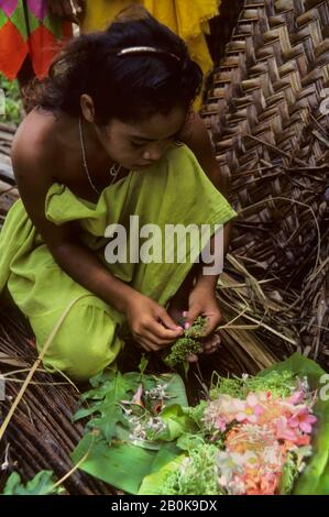 MICRONESIA, CAROLINE ISLS. PULAP ISLAND, NATIVE GIRL MAKING FLOWER LEIS Stock Photo