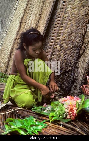 MICRONESIA, CAROLINE ISLS. PULAP ISLAND, NATIVE GIRL MAKING FLOWER LEIS Stock Photo