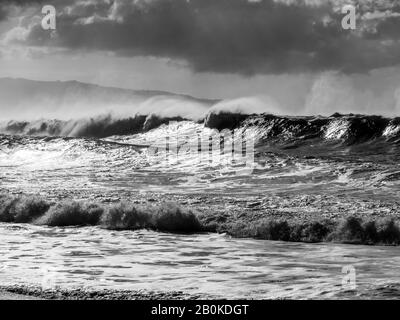 Black and white of big waves on the north shore of Oahu with gray skies  prior to onset of storm. Stock Photo