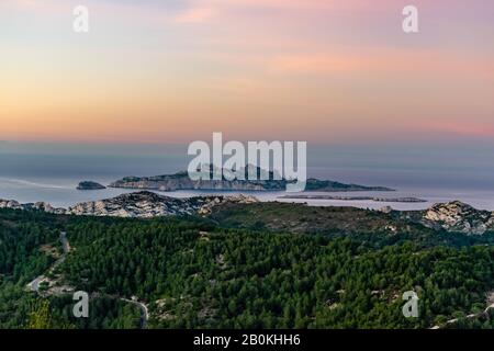 Sunrise at Calanque de Morgiou (Marseille, France): the breathtaking view of the cliff mountain landscape and the island Riou in the distance under th Stock Photo