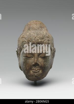 Head of Buddha, China, Tang dynasty (618–907), Date mid-8th century, China, Limestone with traces of pigment, H. 5 1/2 in. (14 cm); W. 3 1/2 in. (8.9 cm); D. 3 1/2 in. (8.9 cm), Sculpture Stock Photo